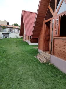 eine Reihe von Gebäuden mit einem Rasenplatz neben ihnen in der Unterkunft Linda Chacara com 2 Chalés em Boituva in Boituva