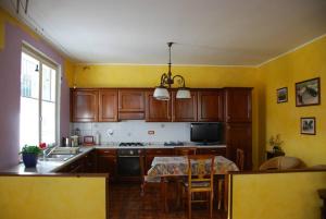 uma cozinha com armários de madeira e uma mesa com uma sala de jantar em Alle porte di Torino, ai piedi del M.te S. Giorgio em Bruino