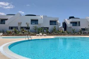 a swimming pool in front of a house at Apartamento Pemedal in Villaverde