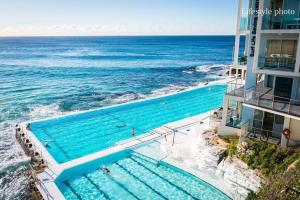 an overhead view of a swimming pool next to the ocean at Bondi Beach House in Sydney