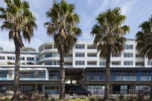 een gebouw met palmbomen ervoor bij Bondi Beach House in Sydney