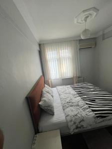 - une chambre avec un lit dans une pièce dotée d'une fenêtre dans l'établissement Kadıköy Holiday Home, à Istanbul