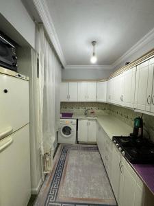 a kitchen with white cabinets and a washing machine at Kadıköy Holiday Home in Istanbul