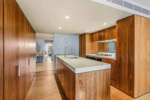een keuken met houten kasten en een wit aanrecht bij Bondi Beach House in Sydney