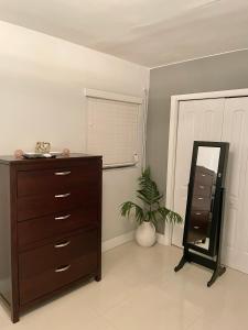 a bedroom with a dresser and a mirror and a plant at Modern Miami Oversized 3 Bedroom in Central Location in Miami
