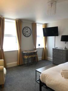 a bedroom with a bed and a clock on the wall at The Stuart Suite - spacious, affordable, city centre in York