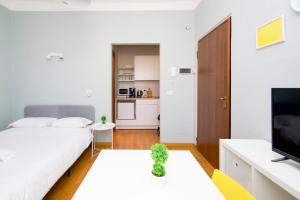 een witte slaapkamer met een bed en een keuken bij Minimal Design in Milano in Milaan