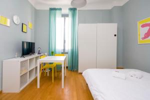 een slaapkamer met 2 bedden, een bureau en een tafel bij Minimal Design in Milano in Milaan