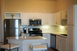 a kitchen with white cabinets and a stainless steel refrigerator at New Apartment in Houston in Houston