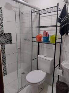 a white bathroom with a toilet and a shower at Casinha Charmosa & Rústica in Indaiatuba