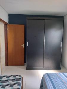 a bedroom with a large closet and a wooden door at Casinha Charmosa & Rústica in Indaiatuba