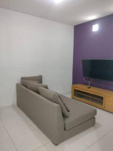 uma sala de estar com um sofá e uma televisão de ecrã plano em Casinha Charmosa & Rústica em Indaiatuba