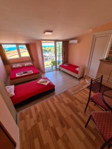 a room with two beds and a table and chairs at Apartments Bulatović in Bar