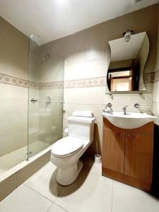 a bathroom with a toilet and a sink and a shower at Ecusuites Penthouse Torre Sol Aeropuerto Mall Del Sol in Guayaquil