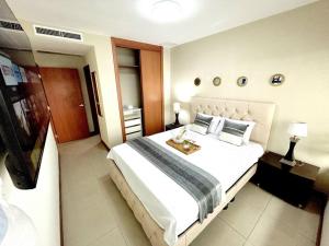 a bedroom with a large white bed in a room at Ecusuites Penthouse Torre Sol Aeropuerto Mall Del Sol in Guayaquil