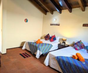 a room with two beds and a room with at Casa Quetzalli, La Merced in Antigua Guatemala