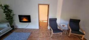 a living room with two chairs and a fireplace at Casa Rural Anais in La Aldea de San Nicolas
