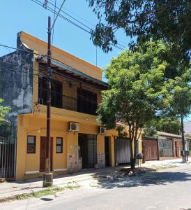 an old yellow building on the corner of a street at Villa Morra House in Asunción