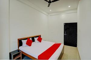 a bedroom with a bed with red and white pillows at OYO Flagship Hotel Bhardwaj in Varanasi