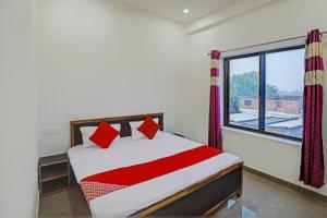 a bedroom with a bed and a large window at OYO Flagship Hotel Bhardwaj in Varanasi