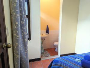 a bedroom with a bathroom with a toilet and a sink at Casa Quetzalli, La Merced in Antigua Guatemala