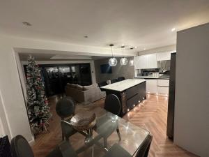 a kitchen and a living room with a christmas tree at 3 bedroom house Hildenborough in Hildenborough