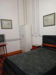 a bedroom with a bed and a white refrigerator at Hotel Tango Club 2 in Buenos Aires