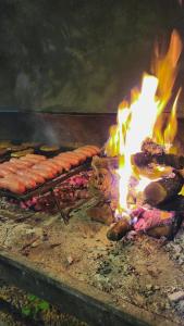 a grill with a bunch of meat and flames at Hotel Juan B Justo in Mendoza