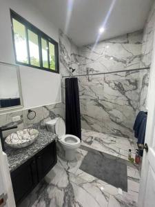 uma casa de banho em mármore com um WC e um lavatório. em Rancho Hope em San Rafael Norte