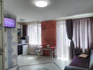 a living room with a couch and a table and a kitchen at Apartment on 8 Marta in Mykolaiv