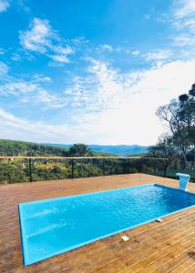 a swimming pool on the deck of a house with a view at Pousada Cabanas Araxá in Urubici