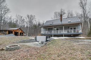 a house with a chair in front of it at Peaceful Cavendish Retreat with Hot Tub and Fireplace! in Proctorsville