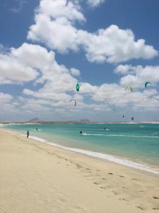 un grupo de personas volando cometas en la playa en Happy Place, Boa Vista, Salrei en Sal Rei