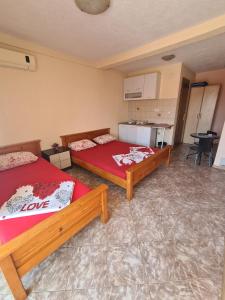 a room with two beds and a kitchen in it at Apartments Bulatović in Bar