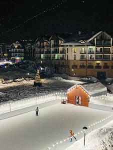 two people are standing on an ice rink in the snow at Hotel Peak in Gudauri