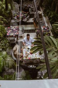 een man aan een tafel in een tuin bij Hotel Casa Lola Deluxe Gallery in Cartagena