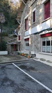 un aparcamiento frente a un edificio de piedra en Auberge Des Pins, en Aubenas
