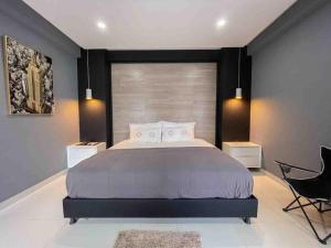 1 dormitorio con 1 cama grande y 1 silla en Rio Hotel lagos, en Leticia