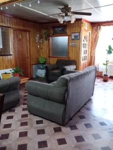 sala de estar con sofá y 2 sillas en Hostal Josmar Natales en Puerto Natales