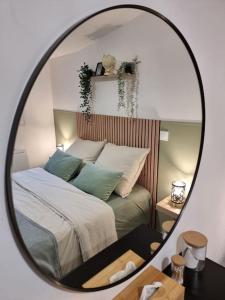 - un miroir réfléchissant le lit dans la chambre dans l'établissement Agréable Logement / Netflix, à Saint-Pierre-des-Corps
