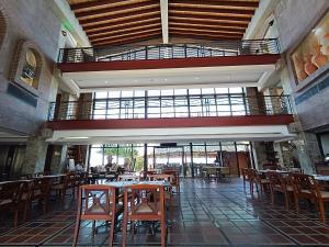 a restaurant with tables and chairs and a balcony at Hotel Eco Inn Jose in Puerto Píritu