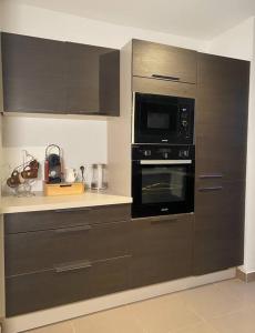 a kitchen with brown cabinets and a microwave oven at The place to B&B - vue lac, 3 chambres et parking privé in Évian-les-Bains