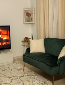 a green couch in a living room with a fireplace at The place to B&B - vue lac, 3 chambres et parking privé in Évian-les-Bains