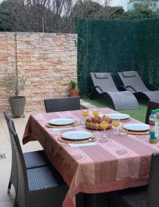 a table with a pink table cloth on a patio at The place to B&B - vue lac, 3 chambres et parking privé in Évian-les-Bains