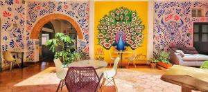 a room with a table and chairs with a painting on the wall at MESON AMELIA in San Miguel de Allende