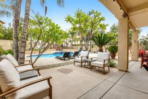un patio con sillas y una piscina con palmeras. en The Oasis at Terramar, en Peoria