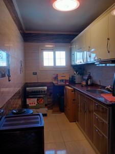 a kitchen with wooden cabinets and a stove top oven at شقة فندقية بالإسكندرية بڤيو لا مثيل له in Alexandria