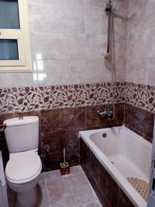 a bathroom with a toilet and a bath tub at شقة فندقية بالإسكندرية بڤيو لا مثيل له in Alexandria