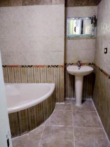 a bathroom with a tub and a sink at شقة فندقية بالإسكندرية بڤيو لا مثيل له in Alexandria