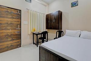 een slaapkamer met een bed en een tafel en stoelen bij SSK Hotel in Lucknow